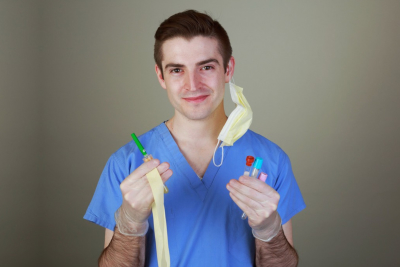 Young male phlebotomist with equipment for drawing blood